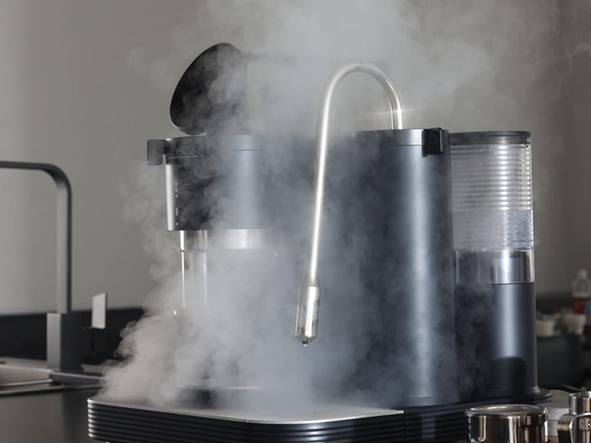 Steam rising around the steam wand and water tank of an espresso machine.